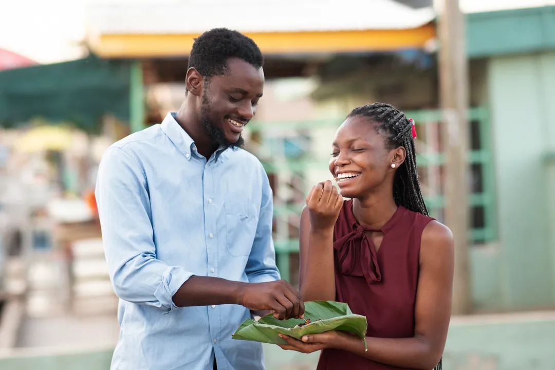 Two friends sharing a moment over street food, settling up between them
