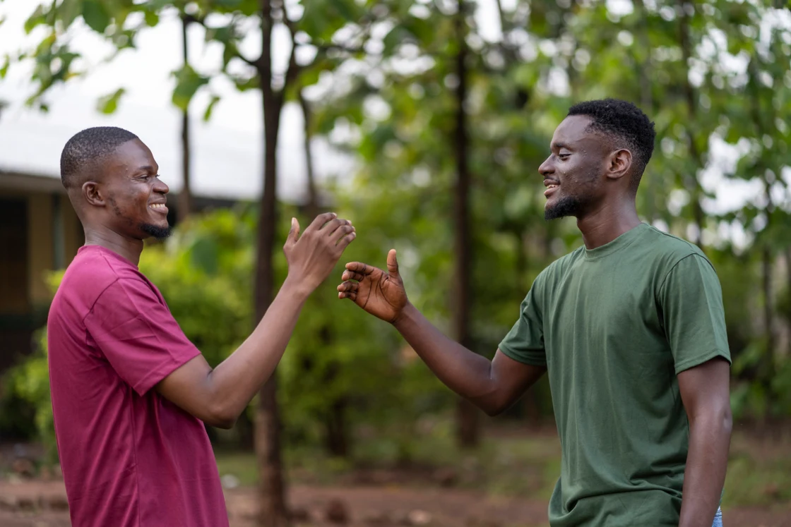 Two friends clasping hands in greeting, the trust that money between people runs on