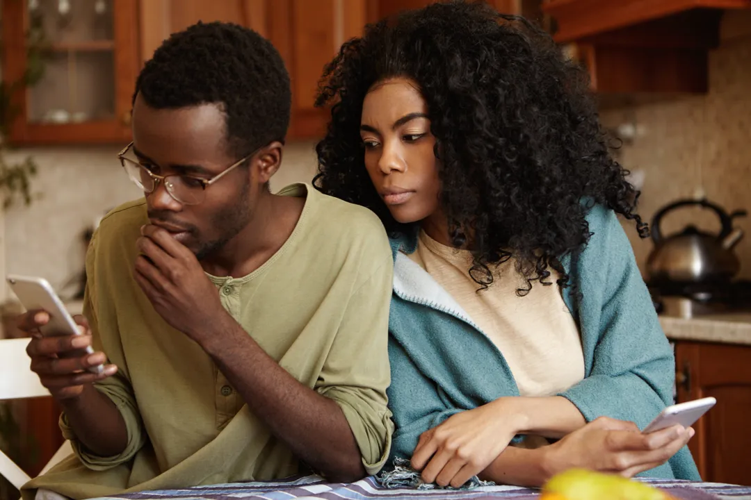 A couple working through money worries from different sides of the same table